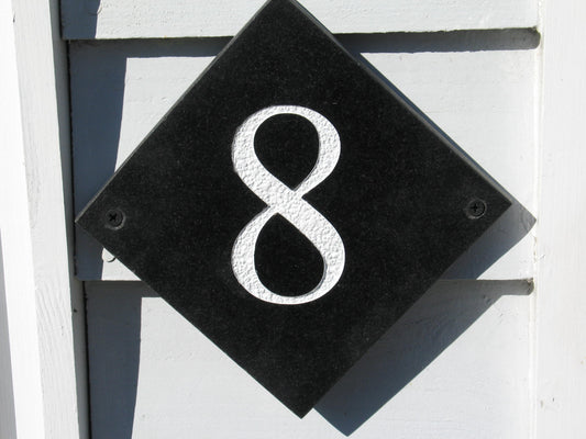 House sign measuring 100mm x 100mm using black Corian with the house number 8 deep engraved and infilled with white monument paint