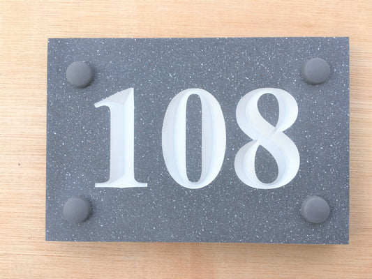 House sign measuring 150mm x 100mm using grey Corian with the house number 108 deep engraved and infilled with white monument paint