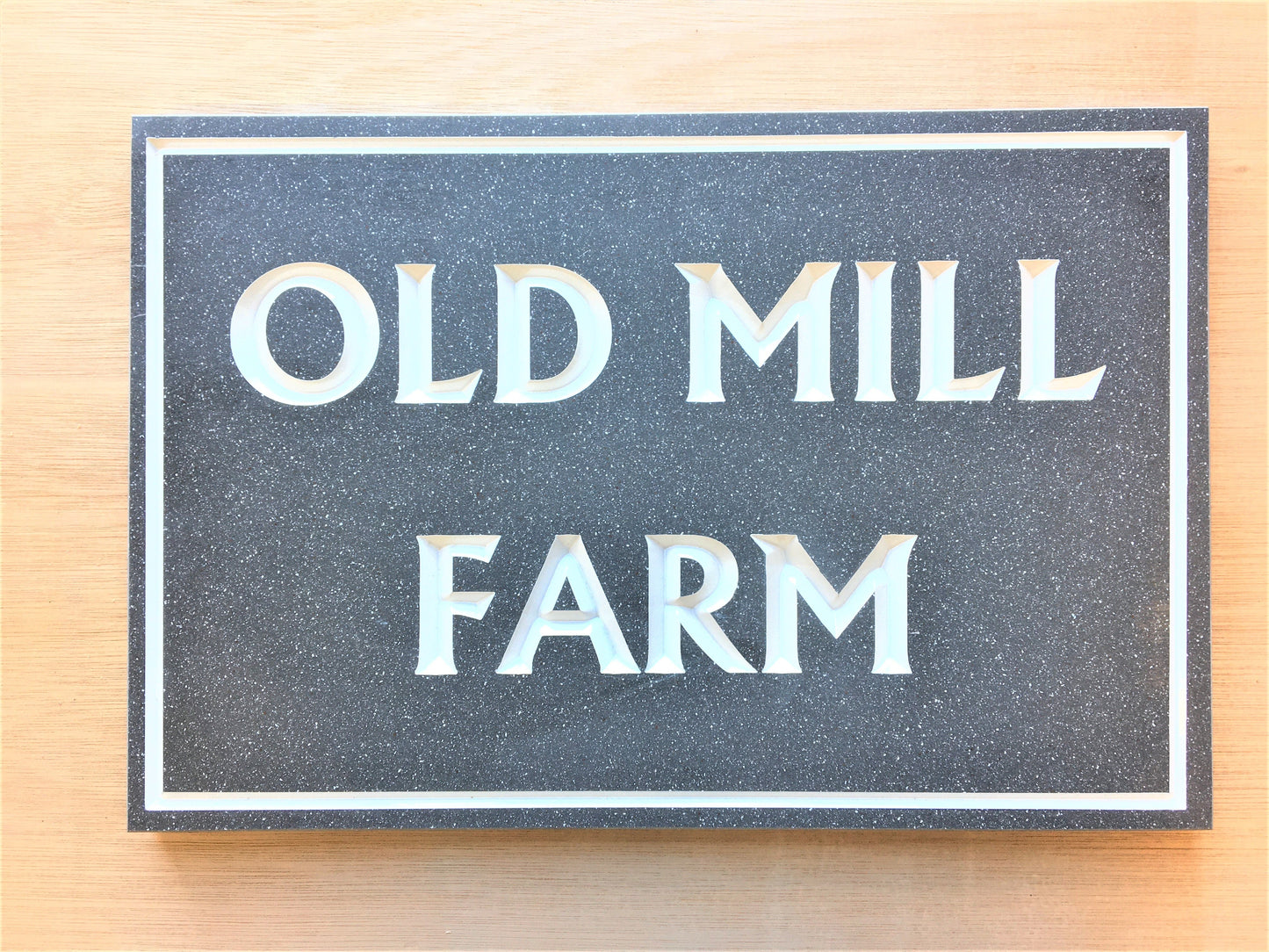 House sign measuring 300mm x 200mm using grey Corian with a plain border and the house name deep engraved and infilled with white monument paint