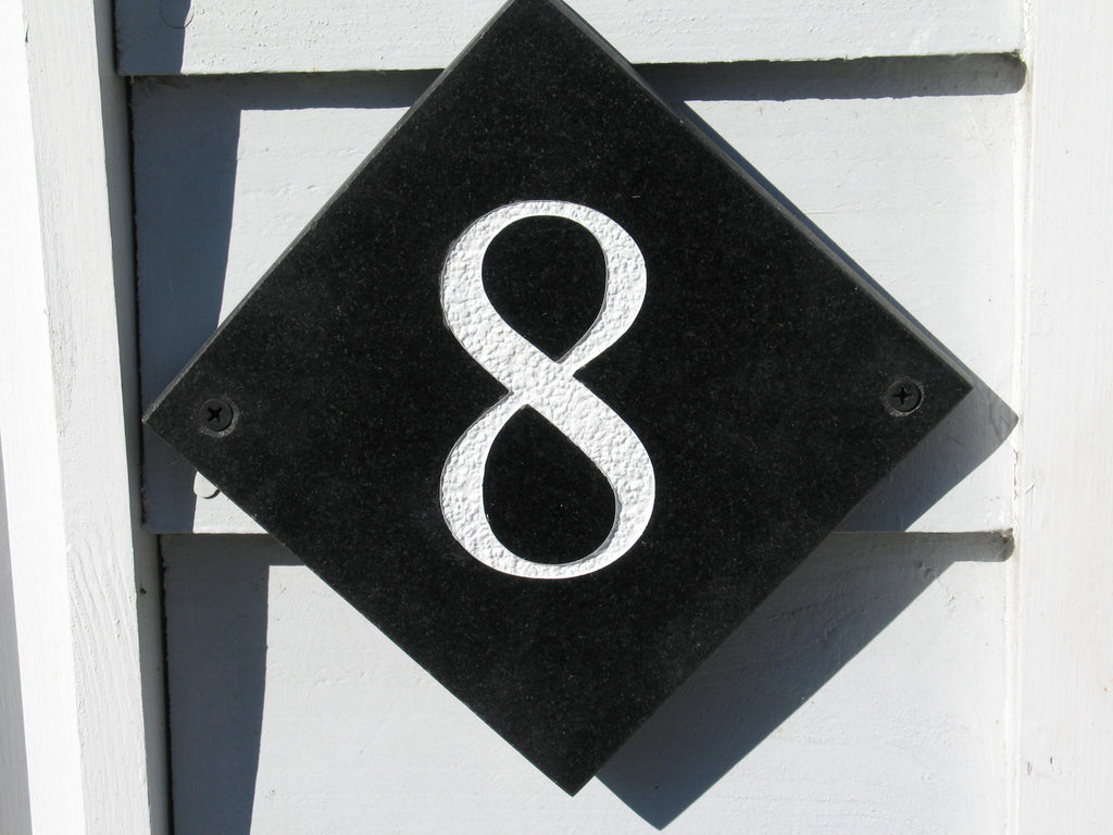House sign measuring 100mm x 100mm using black Corian with the number 8 deep engraved and infilled with white monument paint
