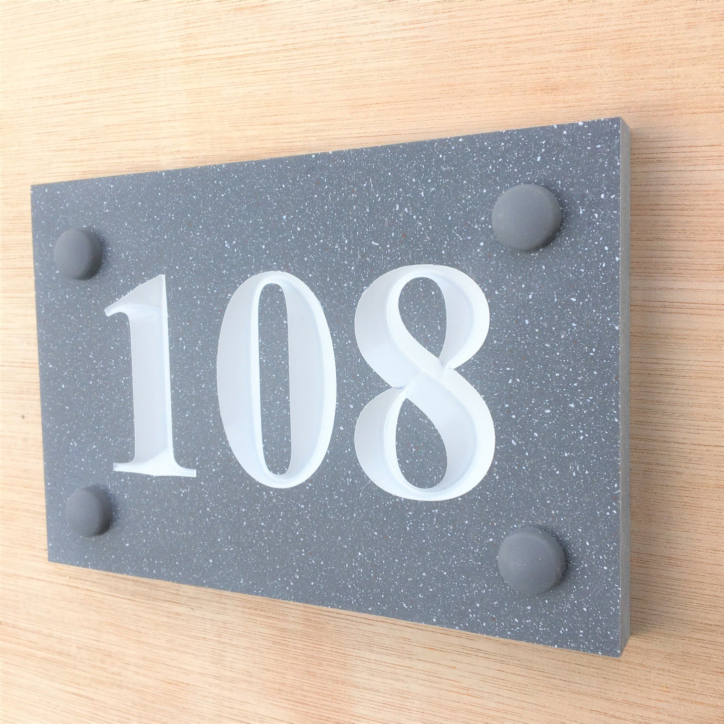 House sign measuring 150mm x 100mm using grey Corian with the house number 108 deep engraved and infilled with white monument paint