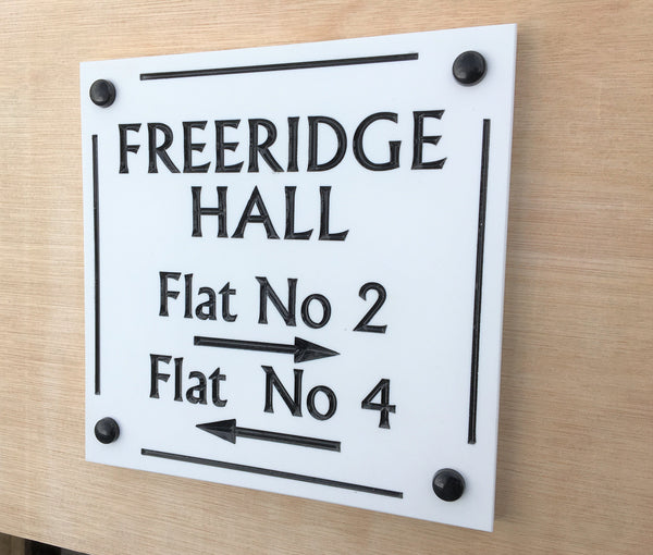 House sign measuring 200mm x 200mm using white Corian with a line border and the address name and numbers deep engraved and infilled with white monument paint