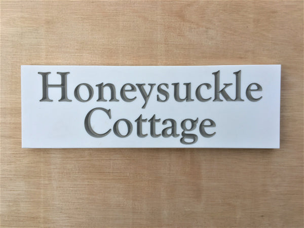 House sign measuring 300mm x 100mm using white Corian with the address deep engraved and infilled with grey monument paint