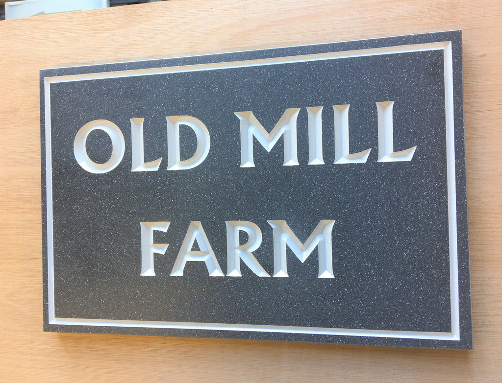 House sign measuring 300mm x 200mm using grey Corian with a plain border and the house name deep engraved and infilled with white monument paint