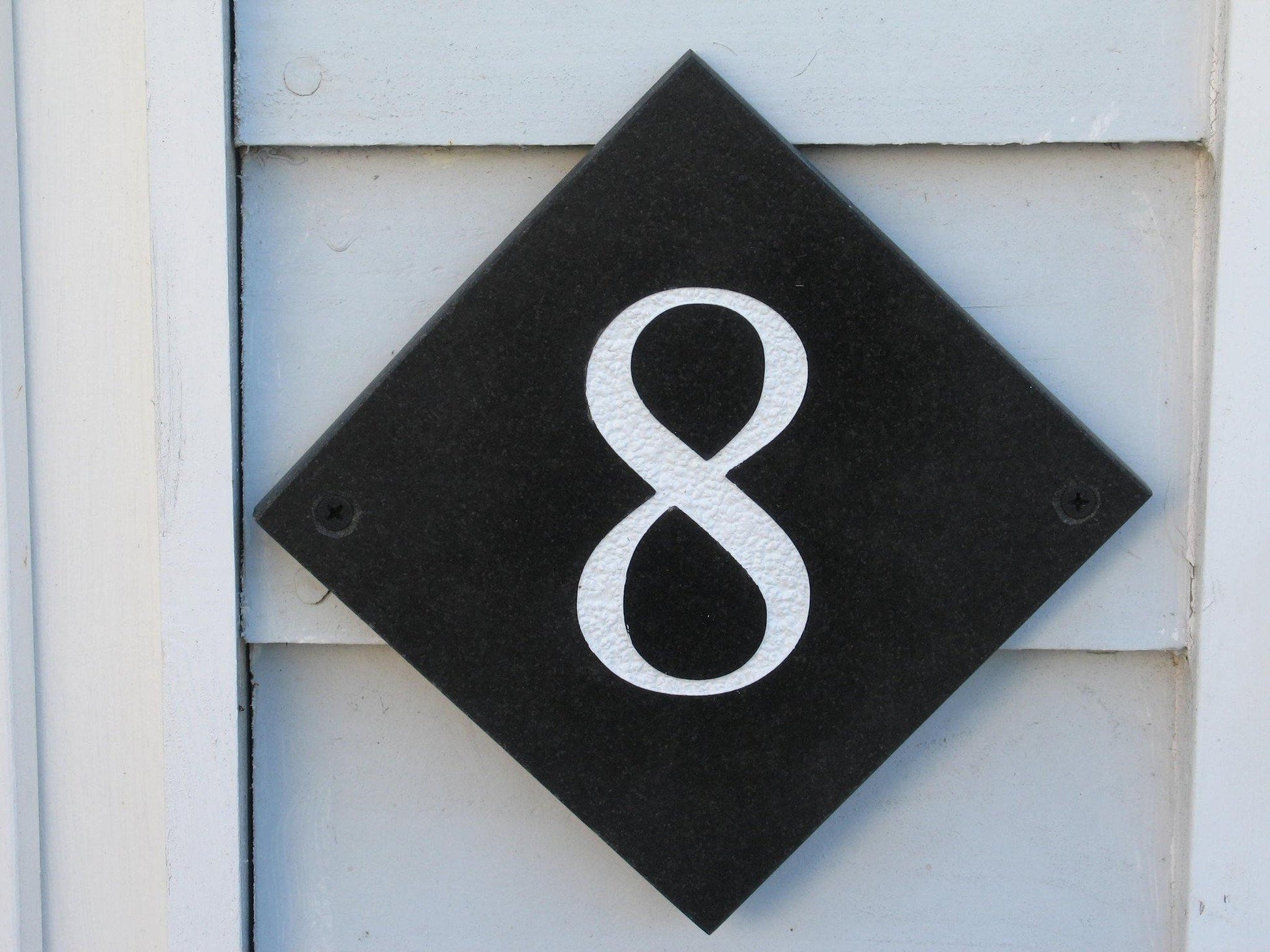 Slate house sign with house number 8 diamond shape 100mm x 100mm using Times New Roman font -on charcoal slate with white paint