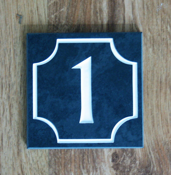 Slate house sign measuring 100mm x 100mm with the number 1 and scalloped border deep engraved on charcoal slate with white paint
