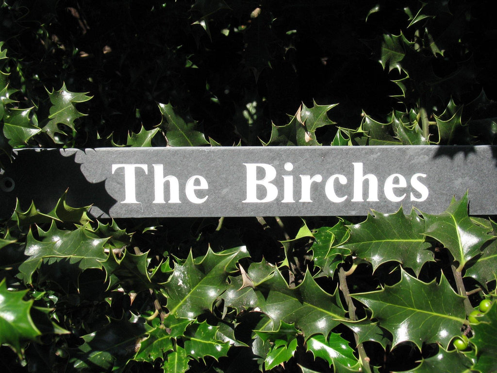 A slate house sign, measuring 400mm x 100mm, deep-engraved house name in Times New Roman font, on grey slate, enhanced with white paint.