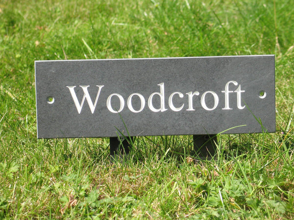 Slate house sign measuring 300mm x 100mm with Woodcroft engraved on grey slate with white paint 