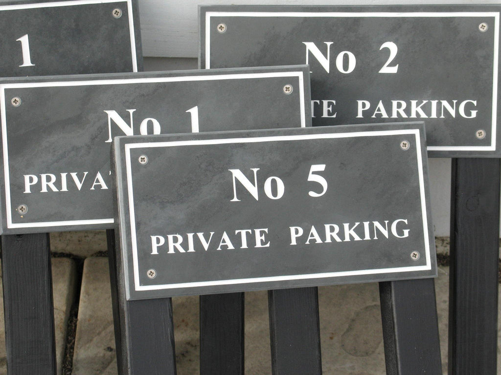 Slate house signs each measuring 300mm x 150mm, engraved in Times New Roman font, on grey slate, with white paint. On two wooden posts.