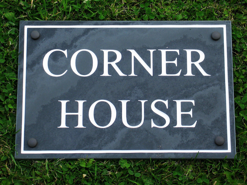 "Charcoal house sign with simple border, displaying the words 'Corner House' in black and white."